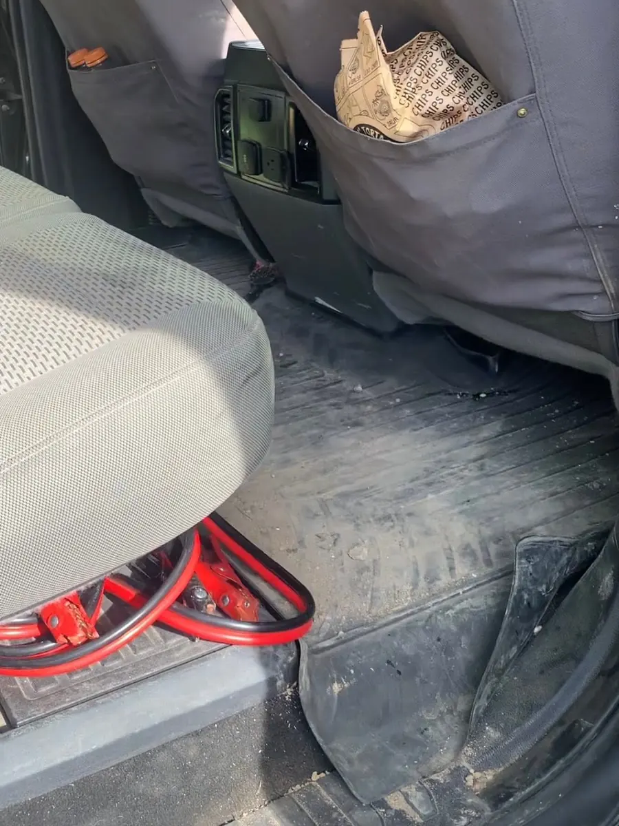 Pickup back seat area with mud on the floor liner before cleaning