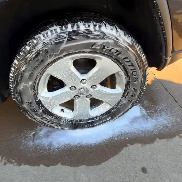Wheel and tire covered in foam during a hand wash